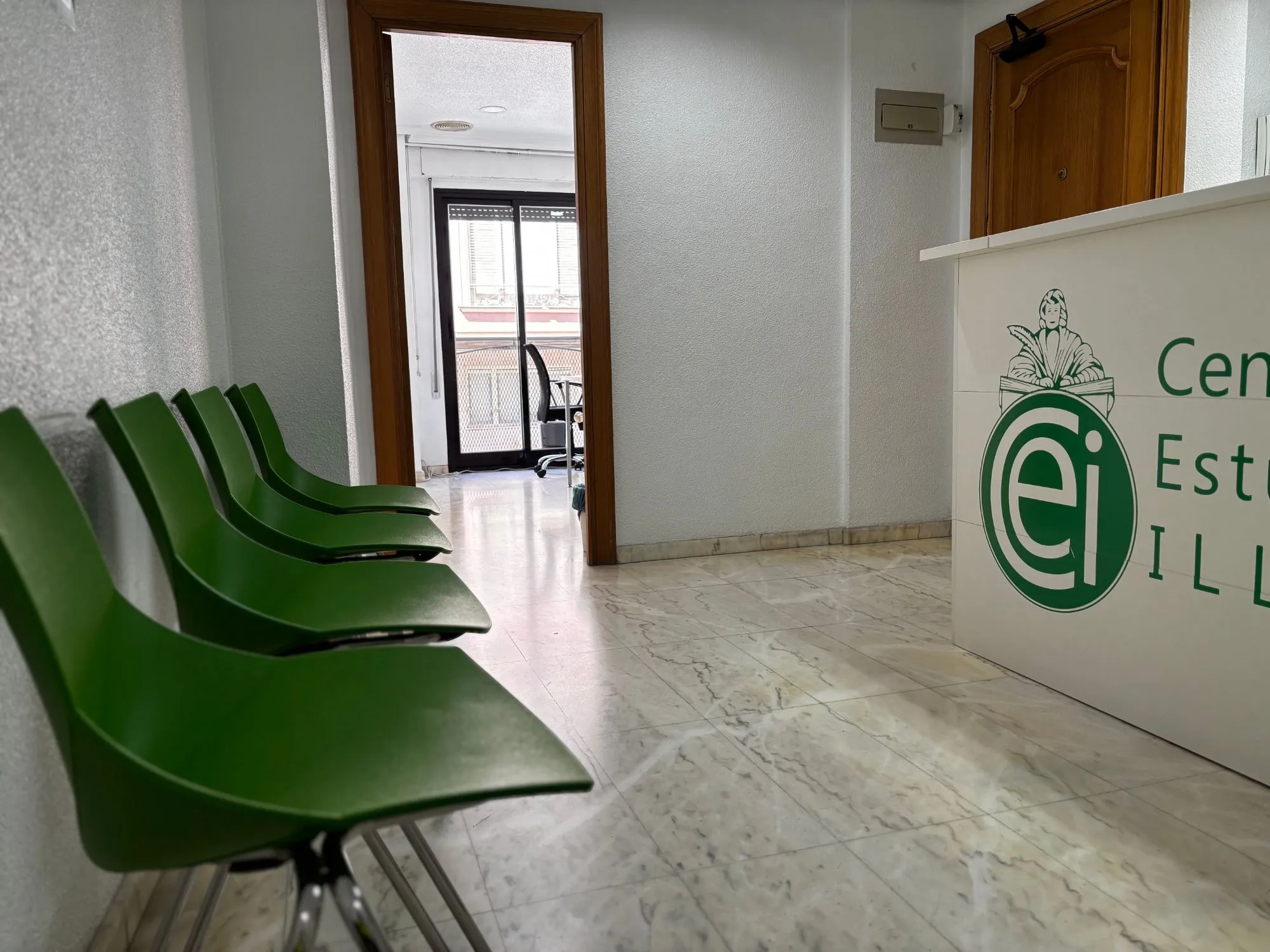 Entrada de la academia con sillas verdes