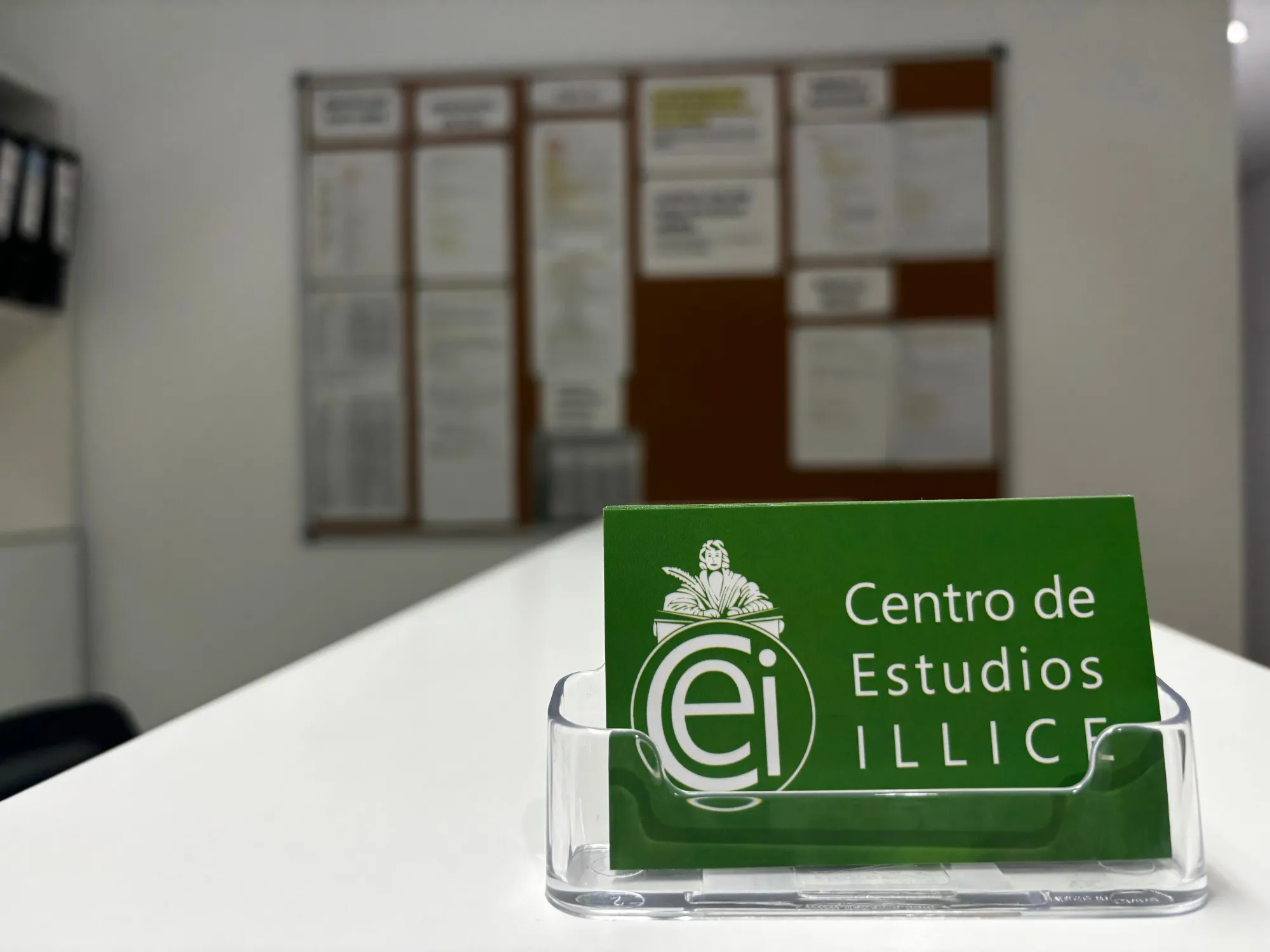 Tarjeta verde del Centro de Estudios Illice en el mostrador